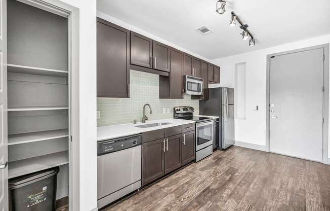 A kitchen with dark brown cabinets and white appliances.