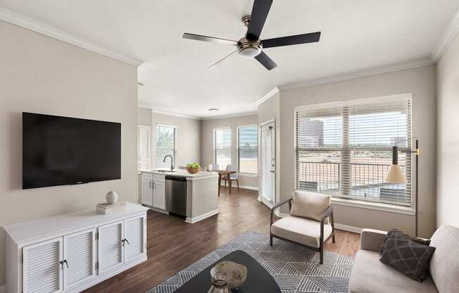 A living room with a television, a couch, and a ceiling fan.