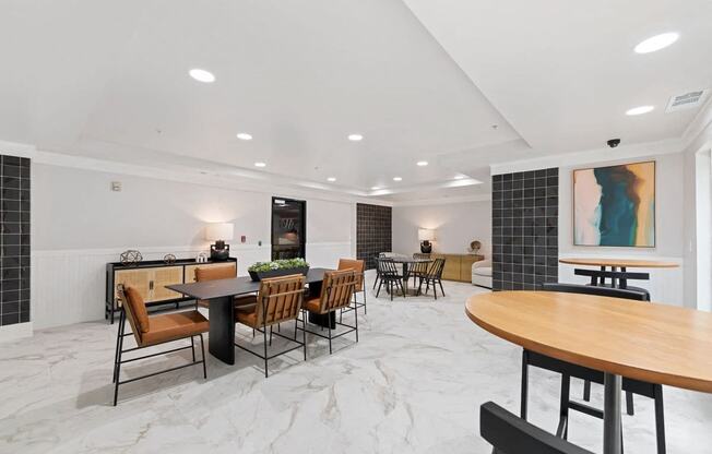 Another angle of the clubhouse with chairs and black coffee tables along with cafe style seating.