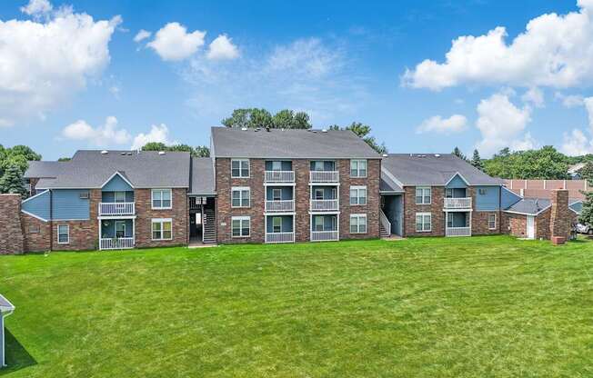 A large brick building with a green lawn in front.