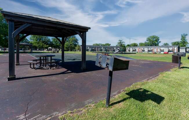 a picnic area with a table and a mailbox in a park