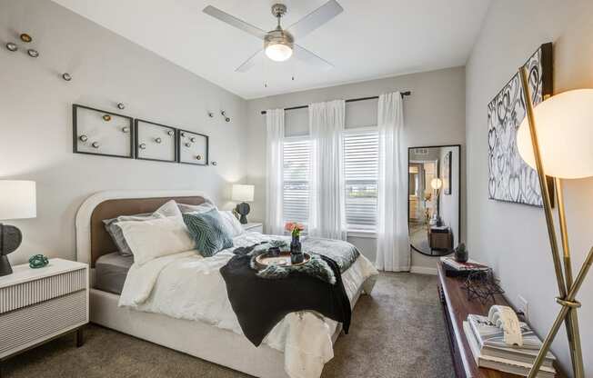 a bedroom with a large bed and a ceiling fan