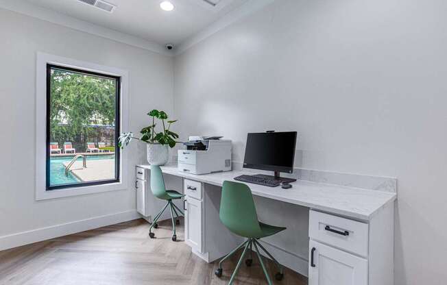 A white desk with a computer and a plant on it.