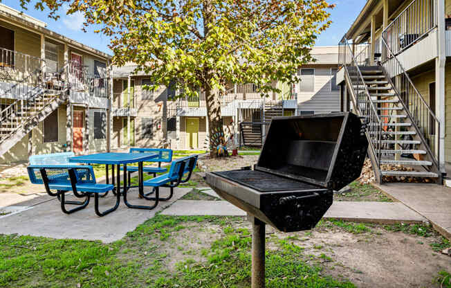 our apartments have a backyard with a grill and a picnic table