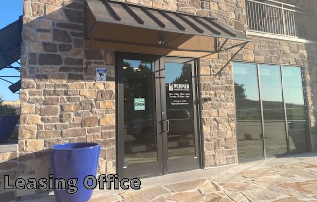 a leasing office with glass doors and a blue trash can