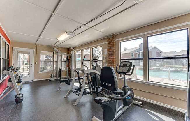 A gym with a row of exercise bikes and a treadmill.