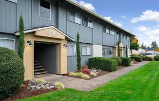A building with a garage door entrance and a small porch area.
