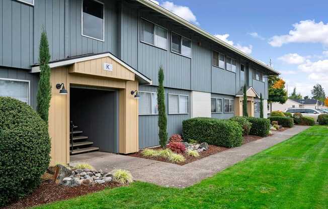 A building with a garage door entrance and a small porch area.