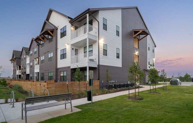 a row of townhomes with a bench in front of them