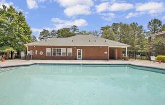 a brick building with a large pool in front of it