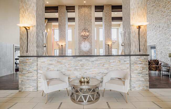 a lobby with two white chairs and a reception desk