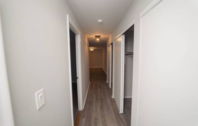 a pass through hallway in a new home with white walls and wood floors  at Enclave West Hartford / Parc West, Connecticut, 06110