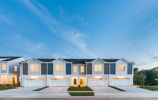 Evening curb appeal at Amavi Brier Creek, featuring modern townhome living in Durham with quick access to Brier Creek shopping, dining, and major roadways.