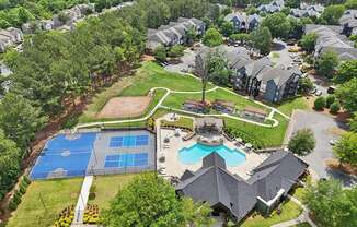 A bird's eye view of a residential area with a swimming pool and tennis court.