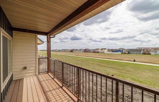 A view from a balcony overlooking a grassy field.
