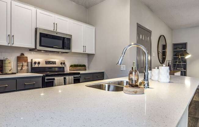A kitchen with a white countertop and a sink.