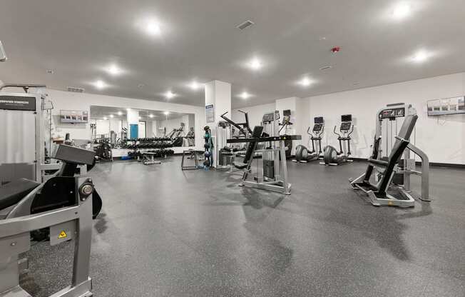 A black and white image of a gym with various exercise equipment.