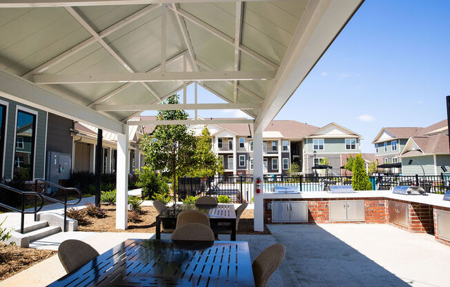 a covered patio with a table and chairs next to a pool