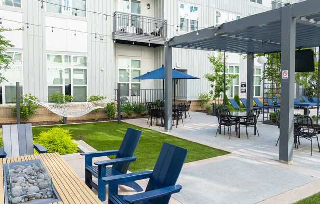 A patio with blue chairs and a table.