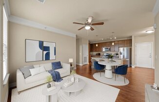 A living room with a white couch and a painting on the wall.