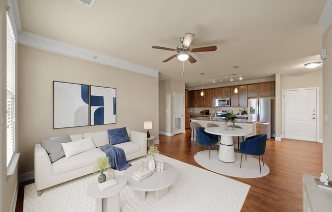 A living room with a white couch and a painting on the wall.