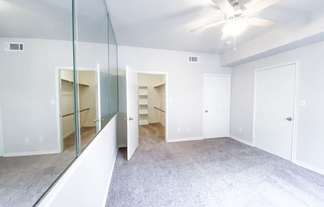 Spacious bedroom with walk in closet at Tuscany Square Apartments in North Dallas, TX. Now leasing studios, 1 and 2 bedroom apartments.