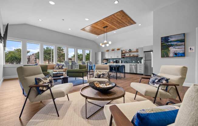 a living room with couches and chairs and a kitchen