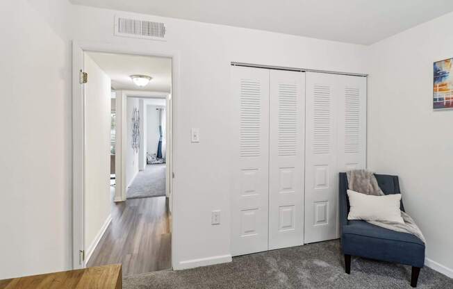 a living room with white doors and a blue chair