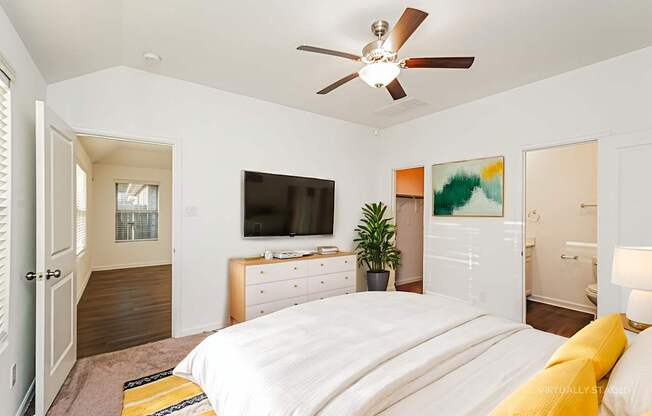 A bedroom with a bed, dresser, and television.