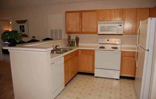 A kitchen with wooden cabinets and white appliances.
