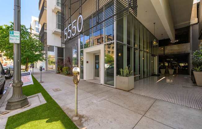 A building with the number 550 on it has a parking sign in front of it.