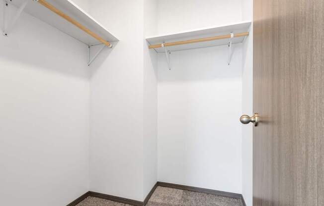 A room with a door, a carpet and a shelf.