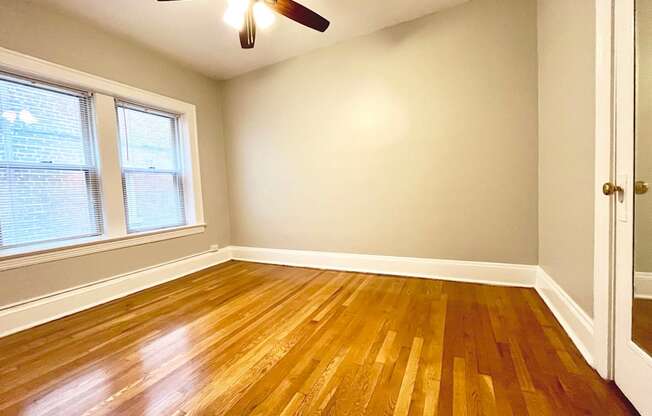 Mapleview bedroom with closet, windows, and ceiling fan.