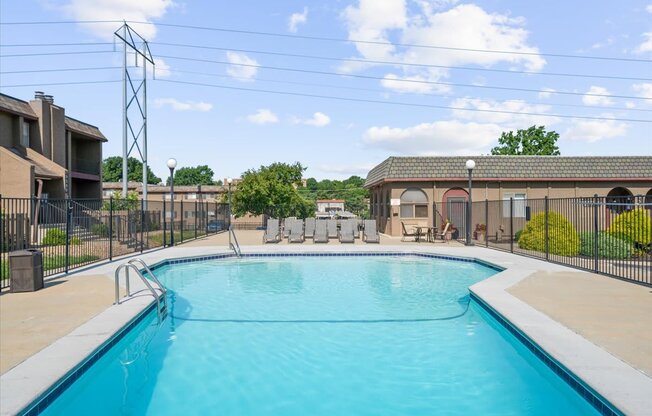 A large outdoor swimming pool surrounded by a fence.