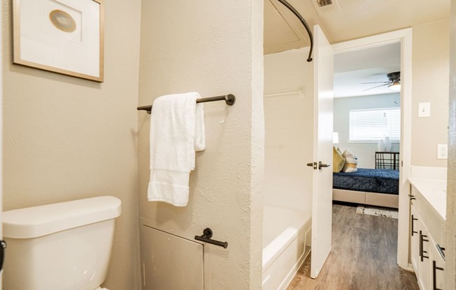 a bathroom with a white toilet and a tub and a shower