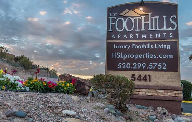 Foothills community sign with well kept entrance accompanied by colorful flowers