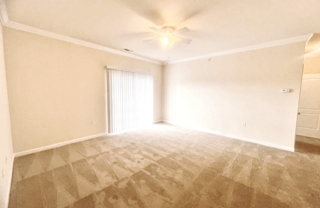 Living room with couch and chair; door to patio or balcony