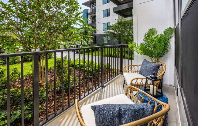 a balcony with two chairs and a table and some plants at The Alibi at Lake Lilly, Ocoee, FL