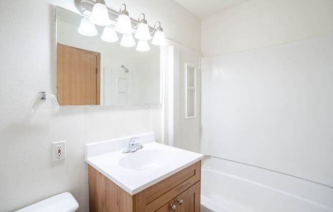 A white sink in a wooden cabinet under a mirror. West Fargo, ND Sheyenne Terrace Townhomes