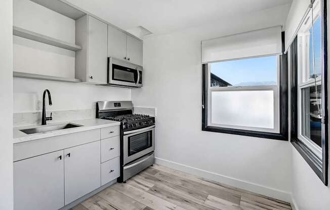 A kitchen with white cabinets and a window.