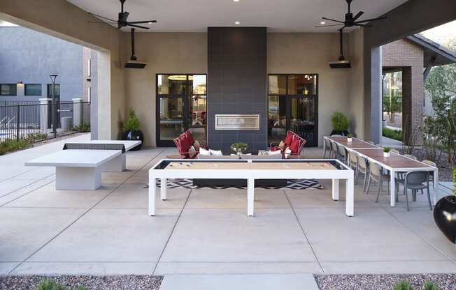 an outdoor patio with tables and chairs and a fireplace