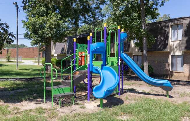 a playground in a park with slides and a bench