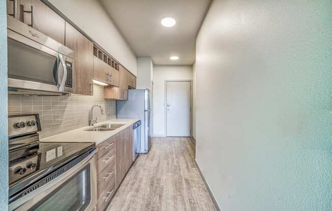 Kitchen with wooden cabinets and stainless steel appliances at Platform 14, Hillsboro, OR