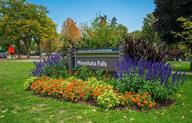 a sign falls in front of a garden of flowers