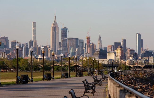 a view of the city skyline from a park with benches at One Ten Apartments, Jersey City , NJ, 07310