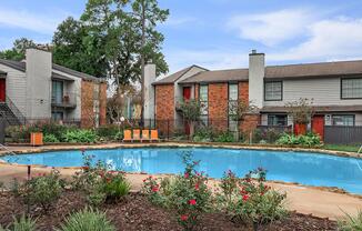 a garden with water in front of a house