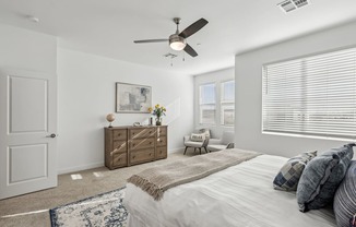 A bedroom with a bed, dresser, and window with blinds.
