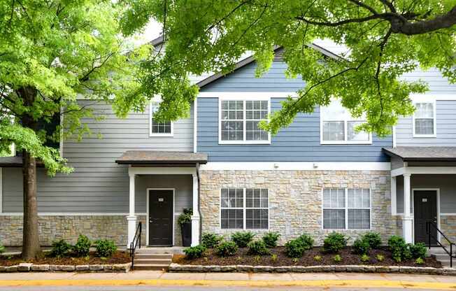 A two-story house with a stone facade and a black front door.