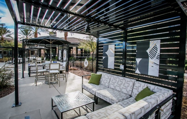 a patio with couches and tables and a pergola