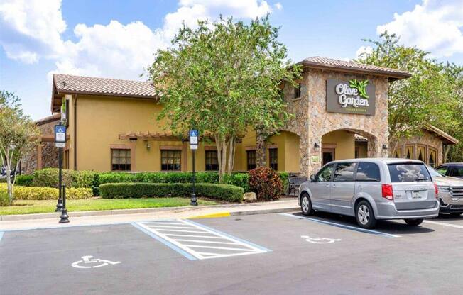 a parking lot in front of a restaurant with a van parked in front